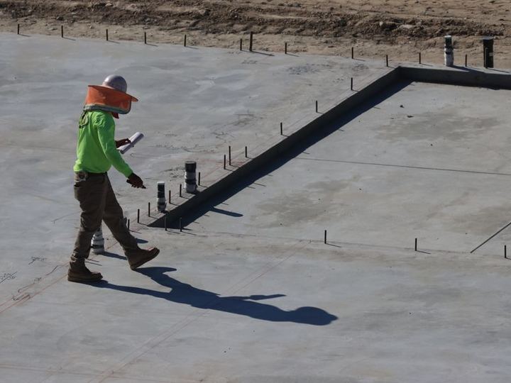 Engenheiro em campo conferindo projeto durante fiscalização